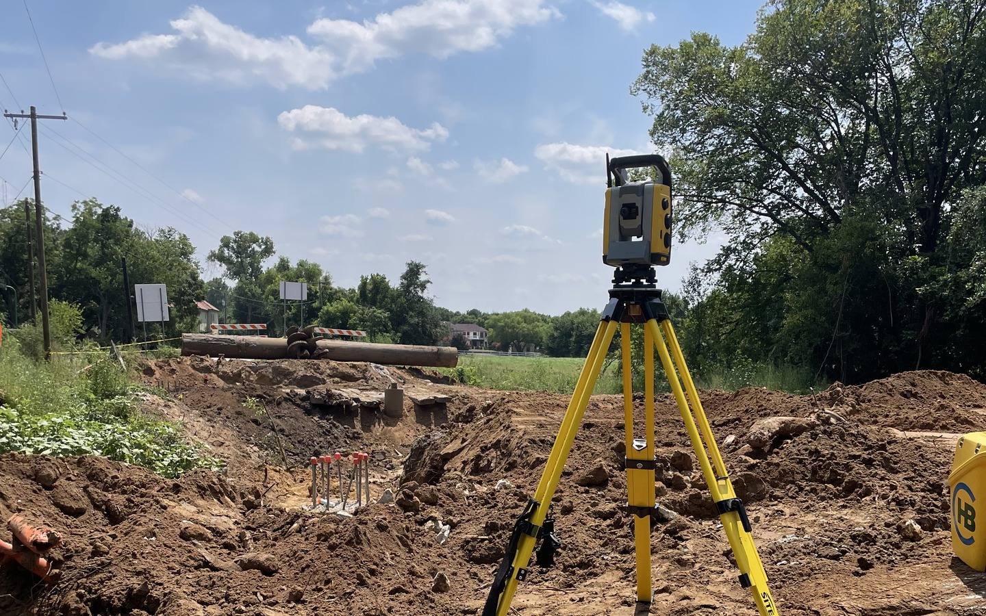 Robotic total station on a tripod, set up on a North Texas construction site